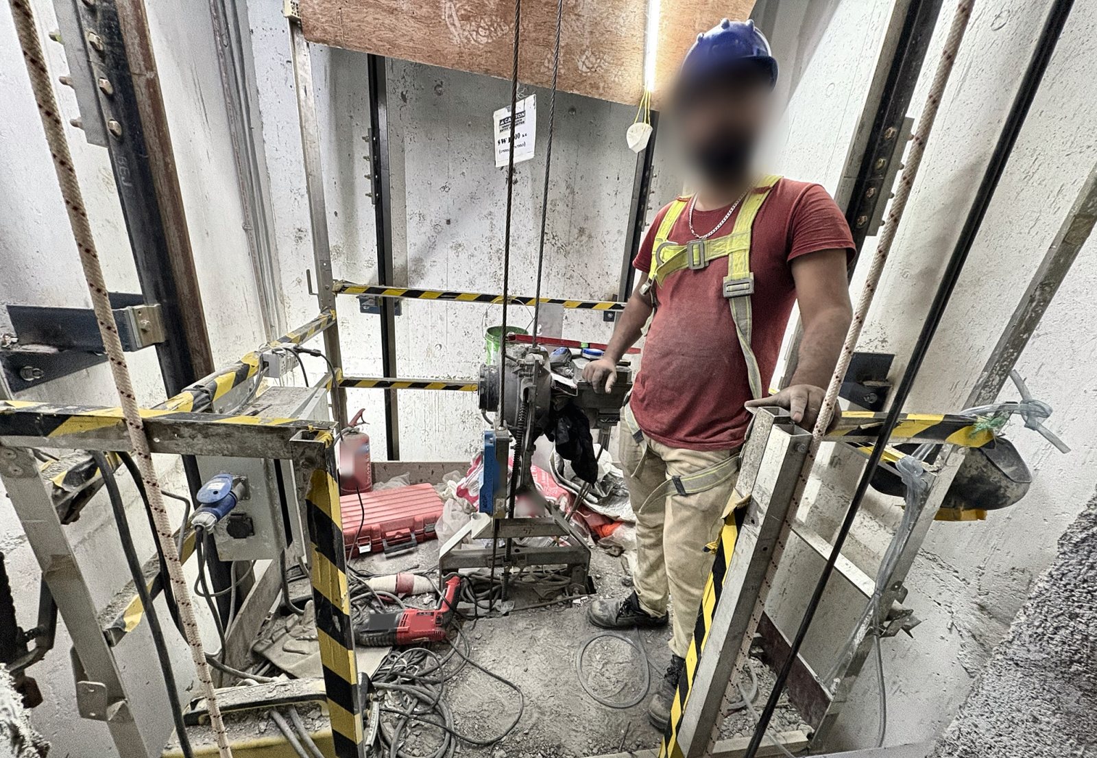 WOS / false car in an elevator shaft with guardrails, hoist, control box and installer
